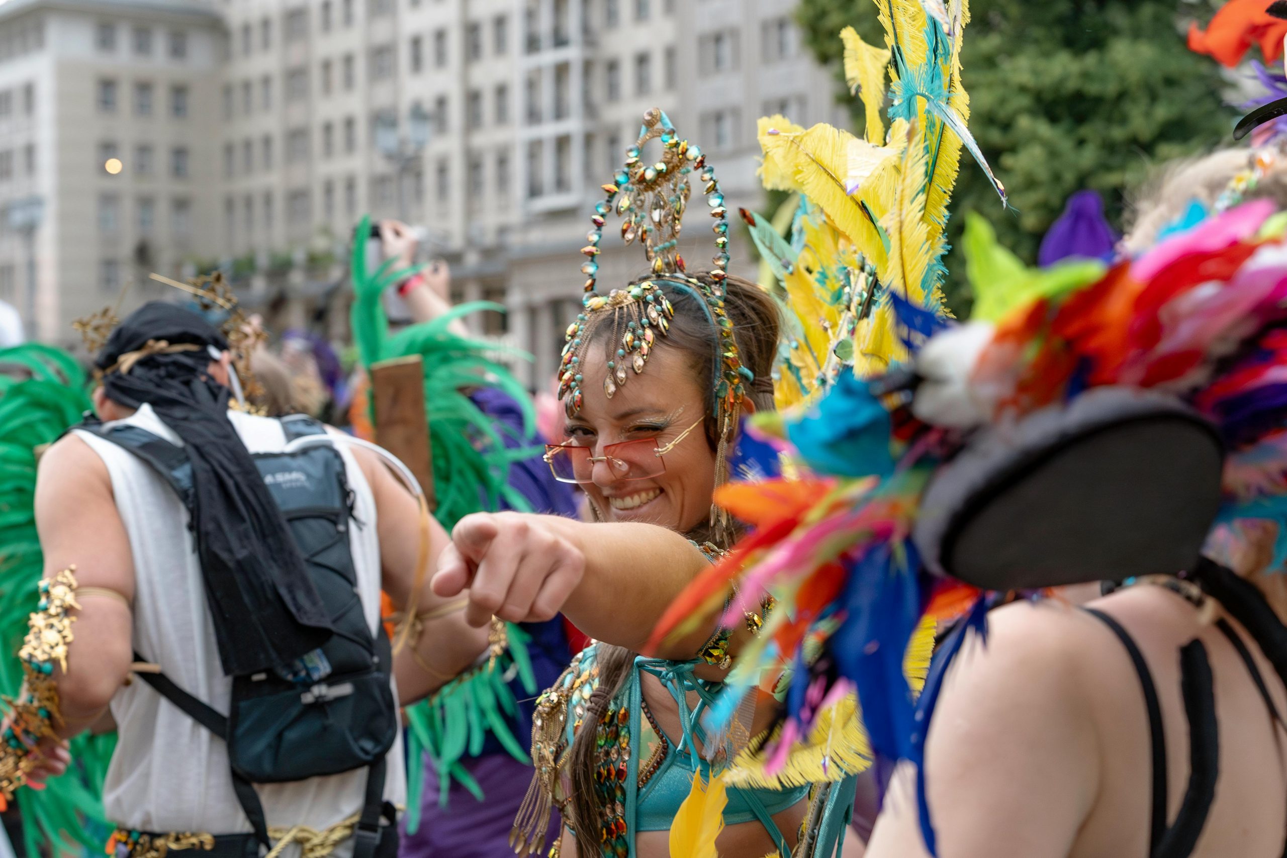 Girl dressed up in gem stones pointing straight and smiling